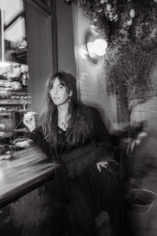 Portrait noir et blanc d’Alice derrière une vitre